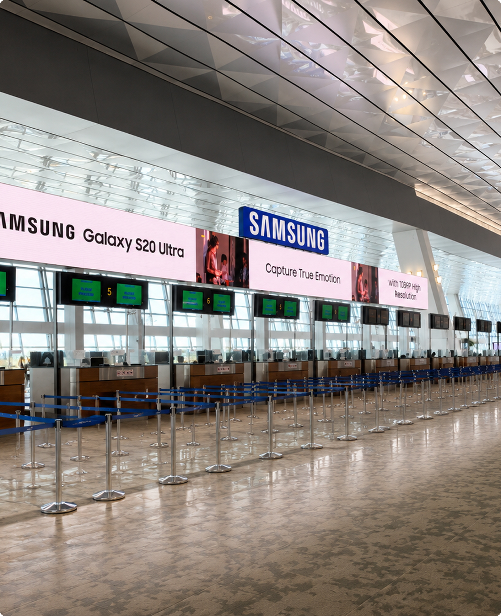 Samsung Galaxy ads on digital screens above an airport check-in hall